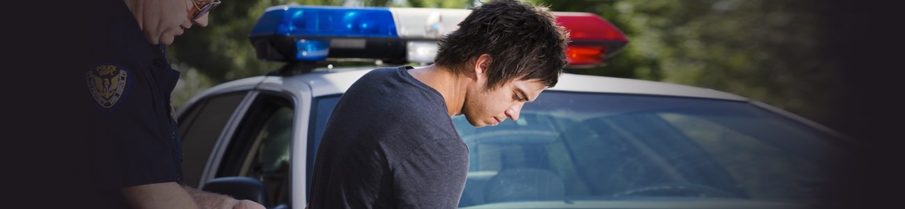 banner picture of police officer putting handcuffs on suspect